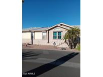 Tan and cream house with blue accent window, palm tree and walkway at 17200 W Bell Rd # 2301, Surprise, AZ 85374