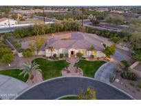 Expansive single-story home with lush green lawn, circular driveway, and desert landscaping at 3527 E Indigo Cir, Mesa, AZ 85213