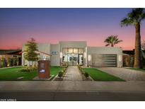 Stunning modern home boasts a sleek design, lush landscaping, and a welcoming walkway to the glass front door at 8319 E Columbus Ave, Scottsdale, AZ 85251