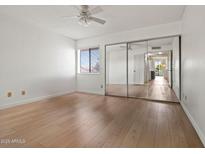 Bright bedroom features hardwood floors, mirrored closet, and natural light at 9125 E Purdue Ave # 214, Scottsdale, AZ 85258