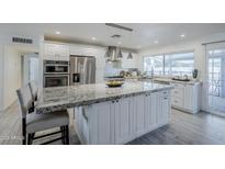 Bright kitchen features white cabinets, stainless steel appliances, granite countertops and a large island at 10844 N 37Th St, Phoenix, AZ 85028