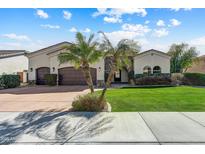 Charming single-story home featuring a well-manicured lawn, desert landscaping, and a three-car garage at 11141 E North Ln, Scottsdale, AZ 85259