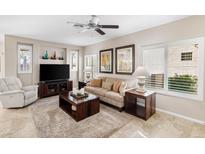 Bright living room features tile flooring, cozy seating, and stylish decor with lots of natural light at 1475 N Agave St, Casa Grande, AZ 85122