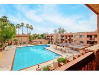 Community pool view with palm trees and blue sky, providing a relaxing resort-like experience at 3031 N Civic Center Plz # 306, Scottsdale, AZ 85251