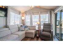 Bright living room with a comfortable couch, chair, and natural light from the surrounding windows at 400 Hawks Eye Dr, Apache Junction, AZ 85119