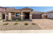 Charming single-story home with desert landscaping, brick driveway, and a two-car garage at 40563 W Michaels Dr, Maricopa, AZ 85138