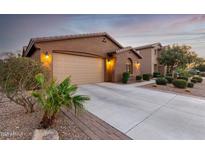 Charming house with two-car garage, a well-maintained lawn and desert landscaping around the house at 631 W Stanley Ave, San Tan Valley, AZ 85140