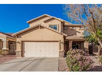 Inviting two-story home featuring a well-maintained front yard with desert landscaping and a two-car garage at 13212 W Lisbon Ln, Surprise, AZ 85379