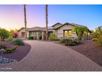 Beautiful single-story home with a circular brick driveway and desert landscaping at 14124 W Christy Dr, Surprise, AZ 85379