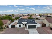 Stunning aerial view of a modern white home with a gray roof and desert landscaping at 15901 S Saxon Rd, Arizona City, AZ 85123