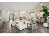 Spacious living room with modern finishes, a large sectional sofa, and an open floor plan to the kitchen at 3675 E Strawberry Dr, Gilbert, AZ 85298