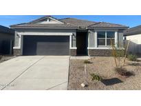 Charming single-story home with neutral gray exterior, rock veneer accents, and a two-car garage at 514 W Freedom St, Florence, AZ 85132