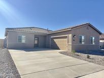 Attractive single-story home with neutral stucco, tile roof, two-car garage, and well-maintained desert landscaping at 635 W Pintail Dr, Casa Grande, AZ 85122