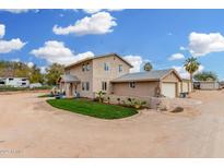 Charming two-story stucco home with well-manicured landscaping and multiple car garage under sunny blue sky at 7515 N 185Th Ave, Waddell, AZ 85355