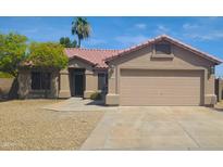 Charming single-story home featuring a tile roof, desert landscaping, and a two-car garage at 9654 N 94Th Ave, Peoria, AZ 85345