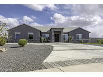 Beautiful single story home boasts an elongated driveway and lovely landscaping at 1455 E Dove Pl, Casa Grande, AZ 85122