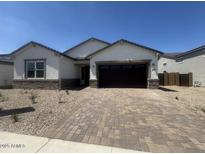 Charming single-story home featuring a brick-paved driveway and neutral-toned stucco exterior at 15822 W Bronco Trl, Surprise, AZ 85387