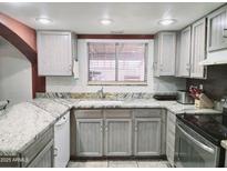 Well-lit kitchen featuring granite countertops and modern stainless steel appliances at 17648 N 36Th St, Phoenix, AZ 85032
