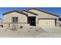A tan single-story home featuring a two-car garage and low-maintenance desert landscaping at 618 W Pintail Dr, Casa Grande, AZ 85122