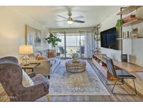 Inviting living room with a stylish rug, comfortable seating, and access to a balcony for outdoor enjoyment at 7625 E Camelback Rd # A438, Scottsdale, AZ 85251