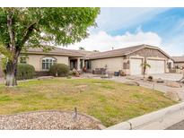 Charming single-story home showcasing well-manicured landscaping and an inviting stone facade at 13516 W Windsor Blvd, Litchfield Park, AZ 85340