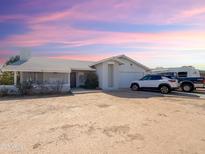 A charming single-story home with neutral colors and a well-maintained front yard under a beautiful sky at 1527 E Garnet Ave, Mesa, AZ 85204