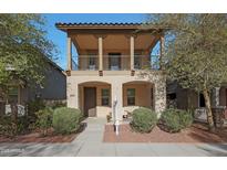 Charming two-story home with a cozy front porch and second-floor balcony, offering inviting curb appeal at 20911 W White Rock Rd, Buckeye, AZ 85396
