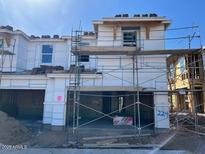 An exterior image of a new home under construction with scaffolding and a partially installed roof at 21130 N 58Th St, Phoenix, AZ 85054