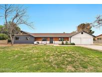 Charming single-story home featuring a well-manicured lawn, neutral exterior paint, and a spacious two-car garage at 4211 W Yorkshire Dr, Glendale, AZ 85308