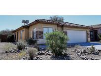 Charming single-story home featuring desert landscaping, a tiled roof, and a two-car garage at 43857 W Bedford Dr, Maricopa, AZ 85138