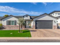 Charming single-story home featuring a well-manicured lawn, brick accents, and a spacious two-car garage at 4846 E Piccadilly Rd, Phoenix, AZ 85018