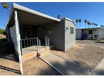 Cozy manufactured home featuring a covered porch and easy-to-maintain landscaping at 5201 W Camelback Rd # 181, Phoenix, AZ 85031