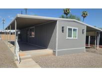 Charming gray home with a covered carport offers shade and protection from the elements at 5201 W Camelback Rd # A7, Phoenix, AZ 85031