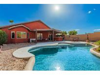Inviting backyard oasis with a sparkling pool and covered patio, perfect for outdoor entertaining and relaxation at 12506 W Dreyfus Dr, El Mirage, AZ 85335