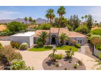Stunning single-story home featuring mature landscaping, a circular driveway, and mountain views at 12755 N 99Th Pl, Scottsdale, AZ 85260