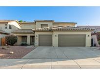 Charming two-story home featuring a tile roof and a spacious three-car garage, complemented by desert landscaping at 12811 W Mulberry Dr, Avondale, AZ 85392