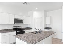 Bright kitchen with stainless steel appliances and gray granite countertops at 1345 S Vista Ave, Florence, AZ 85132