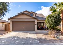 Charming single-story home with a two-car garage, desert landscaping, and a cozy front porch at 1623 W Quick Draw Way, San Tan Valley, AZ 85144