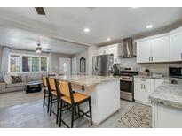 Bright kitchen features a marble island, stainless appliances, and white cabinetry at 1716 N 32Nd Pl, Phoenix, AZ 85008