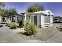 Charming manufactured home featuring covered porch, landscaped yard, and inviting curb appeal at 17200 W Bell Rd # 2152, Surprise, AZ 85374