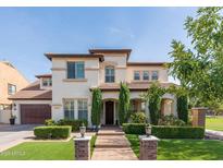 Charming two-story home with a well-manicured front yard and a beautiful brick pathway leading to the entrance at 20311 E Stonecrest Dr, Queen Creek, AZ 85142