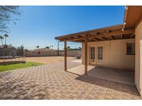 Covered patio extends onto a brick paved area that leads to a large open backyard at 3009 N 81St Ln, Phoenix, AZ 85033