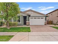 Charming single-story home with a two-car garage, neat landscaping, and a brick driveway at 4197 E Rawhide St, Gilbert, AZ 85296
