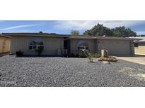 Charming single-story home featuring a gravel front yard, brick accents, arched windows, and an attached two-car garage at 4615 E Emerald Ave, Mesa, AZ 85206