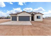 Tan single-story home features a 3-car garage, tile roof, and desert landscaping under a blue sky at 5145 E Hash Knife Draw Rd, San Tan Valley, AZ 85140