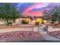 Beautiful single-story home featuring desert landscaping, stone accents, and inviting curb appeal at sunset at 13007 W Tuckey Ct, Glendale, AZ 85307