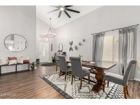 Bright dining room features wood floors, modern lighting, and gray chairs at a trestle table at 21740 W Sonora St, Buckeye, AZ 85326