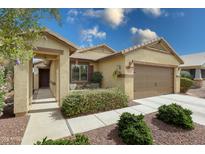 Inviting single-story home featuring desert landscaping, a two-car garage, and a charming covered front porch at 3519 S 185Th Dr, Goodyear, AZ 85338