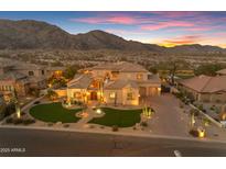 Stunning sunset view of an estate home featuring desert landscaping, a grand entrance and multiple garage bays at 3616 E Kachina Dr, Phoenix, AZ 85044