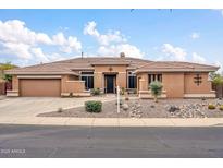 Stunning single-story home with a tile roof, desert landscaping and a circular driveway provides excellent curb appeal at 42105 N Golf Crest Rd, Anthem, AZ 85086